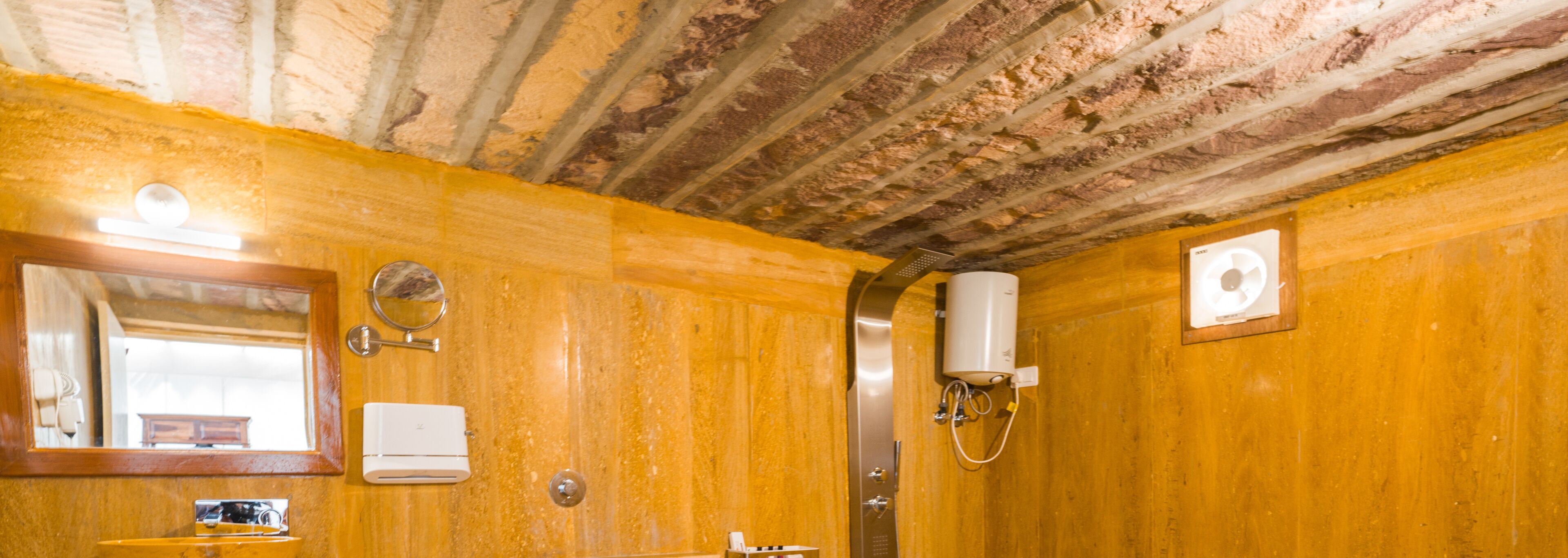 Une salle de bain avec des murs en bois, un miroir, un porte-serviettes, un lavabo et une douche.