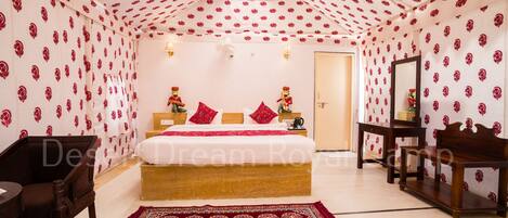A bedroom with a bed, a nightstand, a wooden chair, a wooden bench, and a patterned rug.