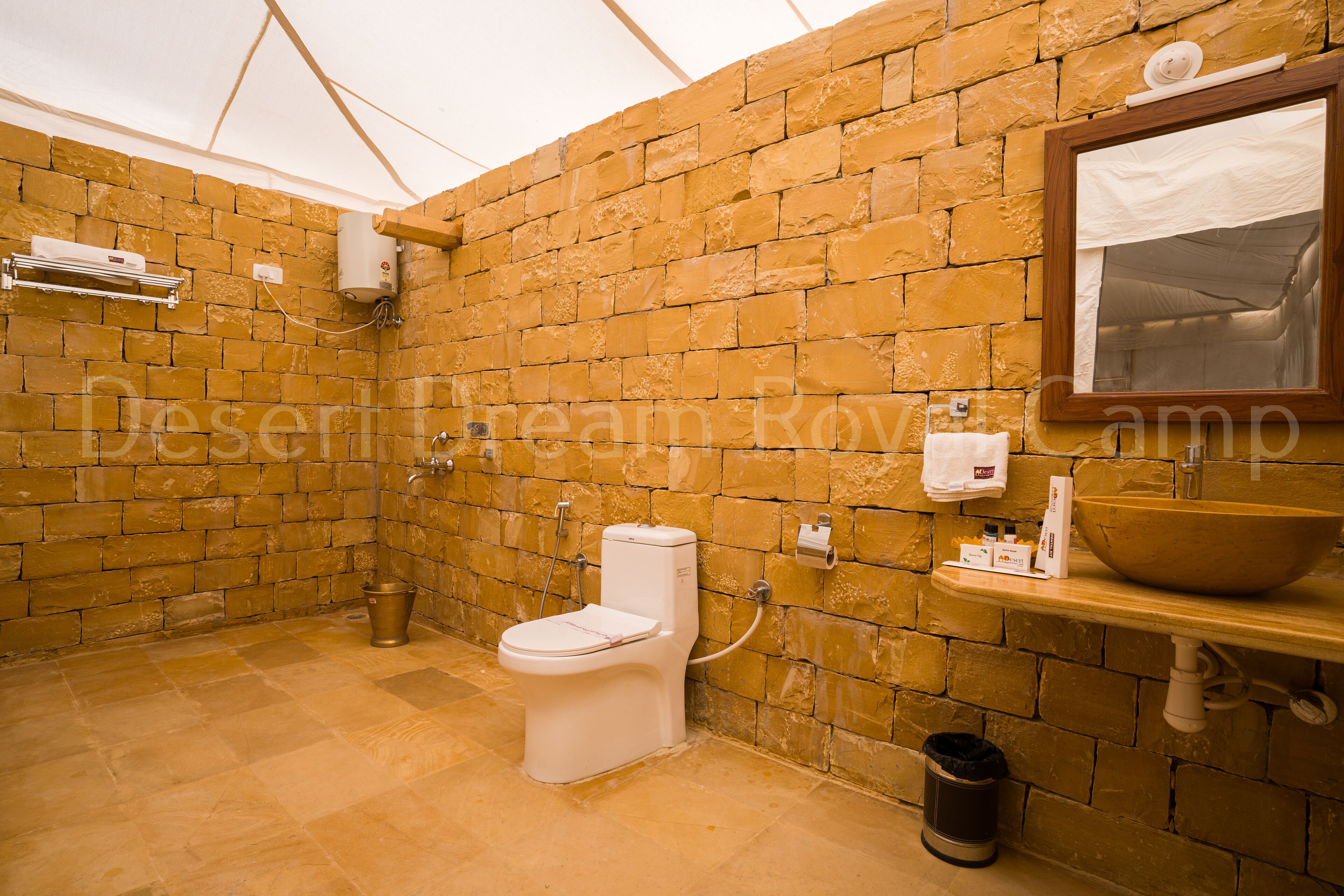 Une salle de bain avec un mur en briques, des toilettes, un lavabo et un miroir.