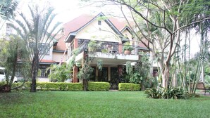 A two-story house with a balcony, surrounded by well-maintained greenery and a lawn. - Stunning Mansion (Nairobi)