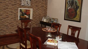 A dining room with a wooden table, chairs, and a decorative centerpiece. - Stunning Mansion (Nairobi)