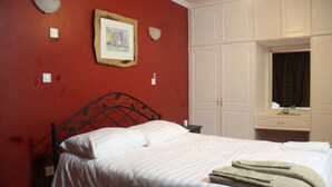 A bedroom with a bed, a framed picture on the wall, and a window with curtains. - Stunning Mansion (Nairobi)