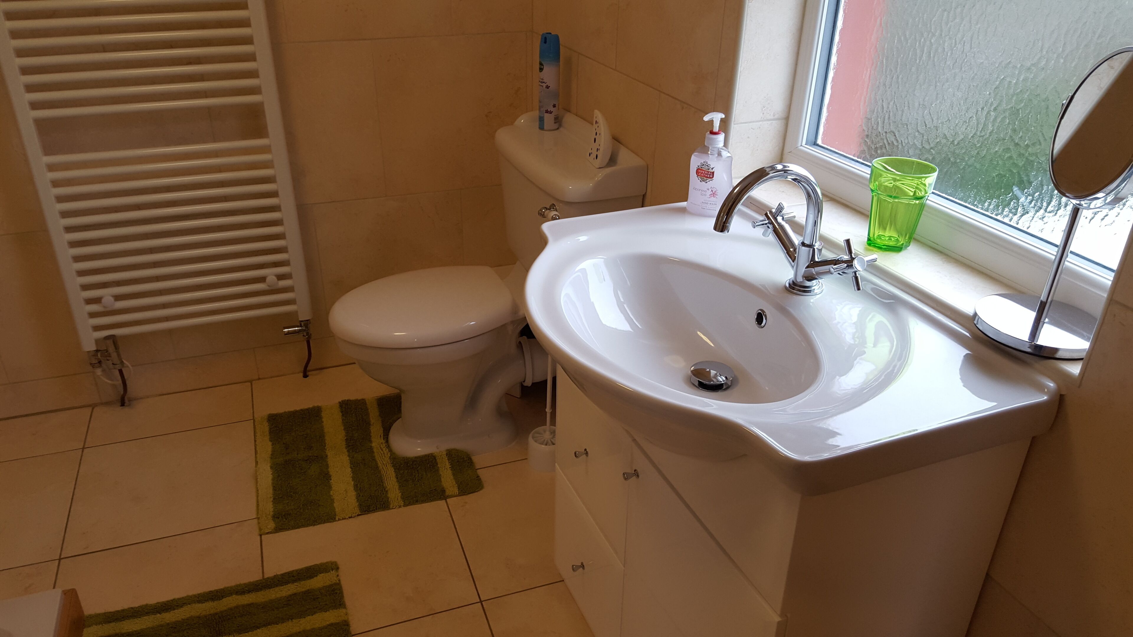 Un baño con inodoro, lavamanos y ventana.