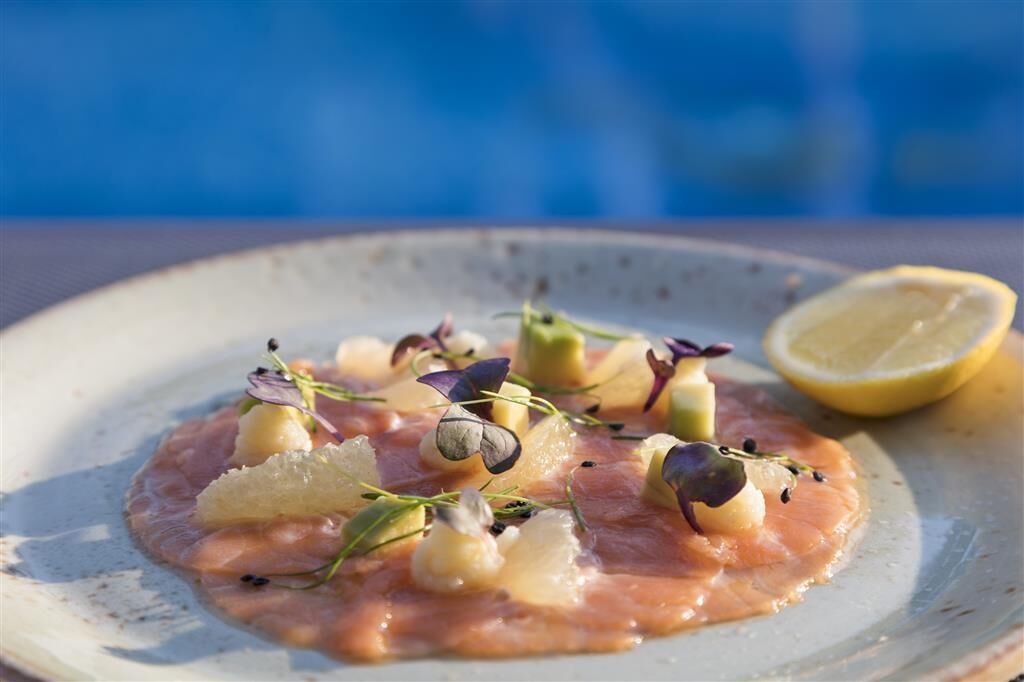 Prato com salmão, acompanhamentos e metade de limão.