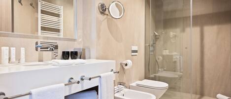 Une salle de bain moderne dotée d’une douche à parois de verre, d’un bidet et de toilettes.