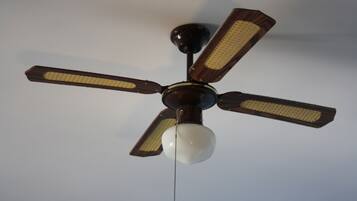 Un ventilador de techo con cuatro aspas y una lámpara central.