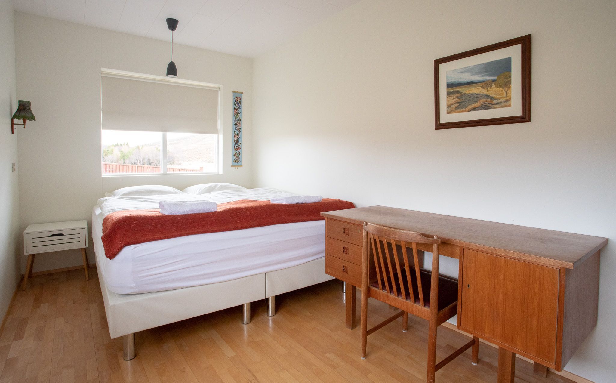 A bedroom with a bed, a desk, and a chair.