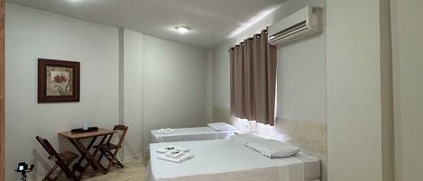 Una habitación de hotel con una cama, un escritorio y una silla.
