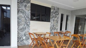 A modern interior with wooden tables and chairs arranged for dining. - Hotel Pousada Figueiredo (Araruama)