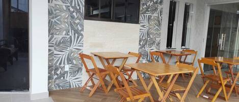 A modern interior with wooden tables and chairs arranged for dining.
