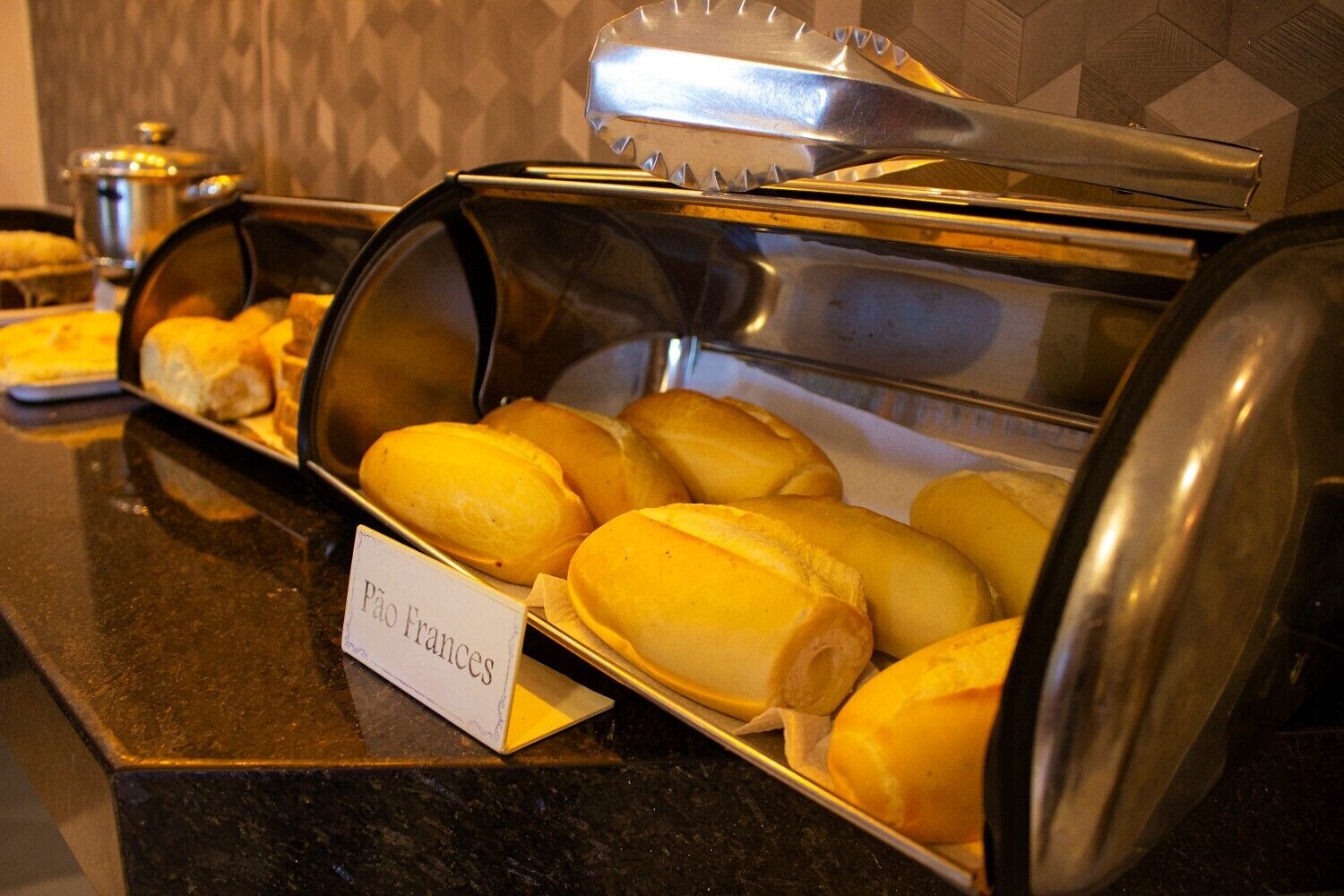 A buffet with a sign labeled "Pão Frances" indicating French bread.