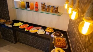 A buffet with various food items and condiments. - Hotel Pousada Figueiredo (Araruama)