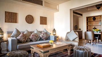 A modern living room with a sofa, ottomans, a coffee table, and decorative wall art.