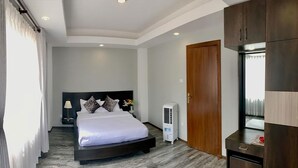 Quarto moderno com cama, mesa de cabeceira, luminária e armário.