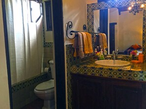 A bathroom with a toilet, sink, and mirror.