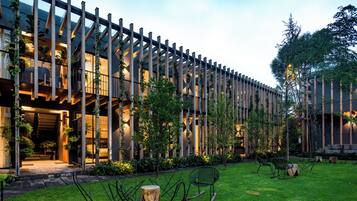 A modern building with a wooden facade, a well-maintained lawn, and outdoor seating.
