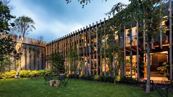 A modern building with vertical wooden slats, a well-maintained lawn, and outdoor seating.