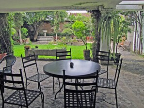 An outdoor patio with a round table and six chairs. - Casita Santa Rosa (Antigua Guatemala)