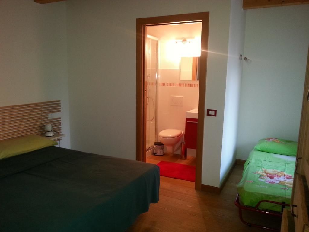 A bedroom with a bed, a bedside table, a nightstand, and a window.