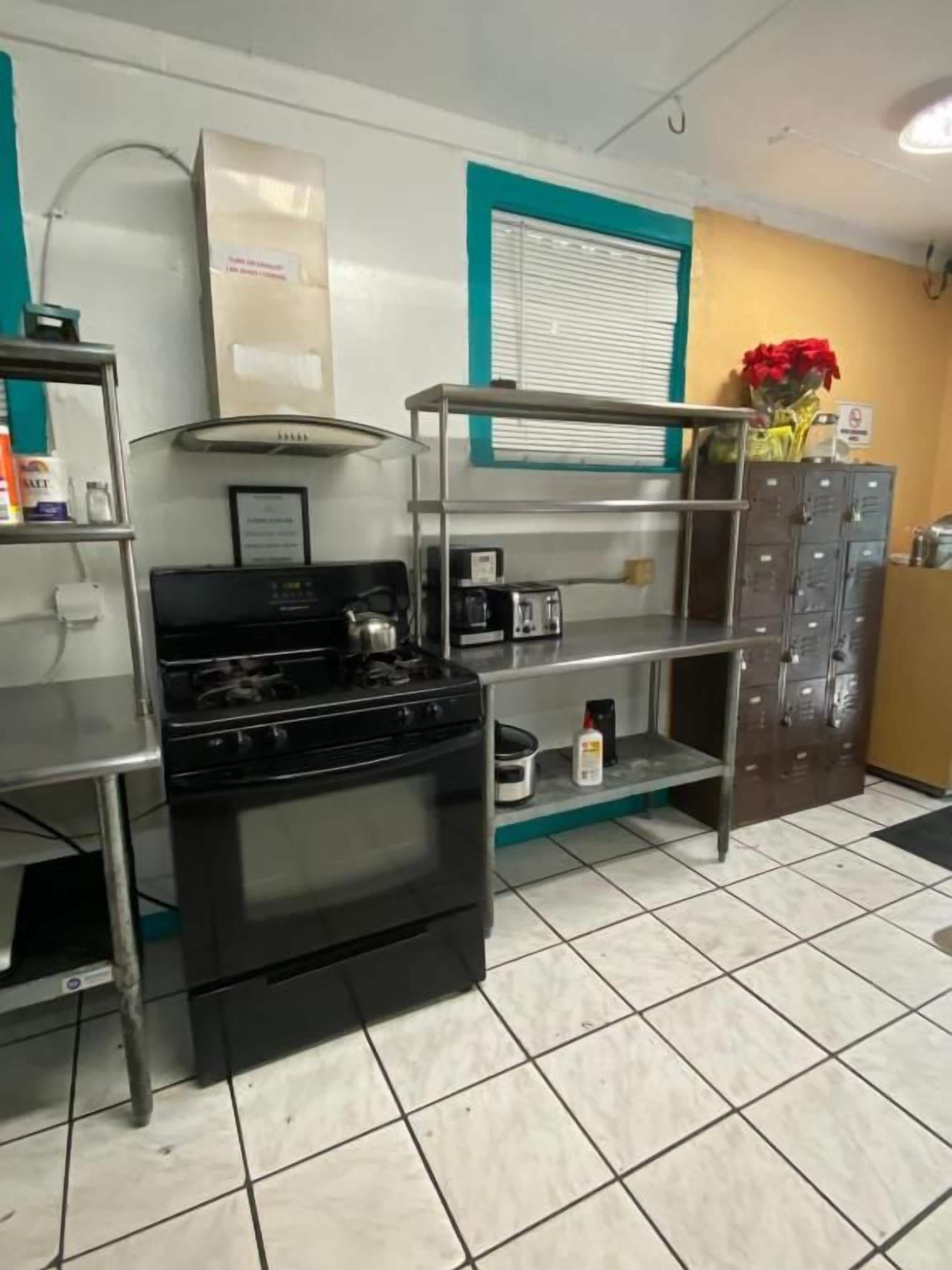 Una cocina con estufa, microondas y gabinetes de acero inoxidable.