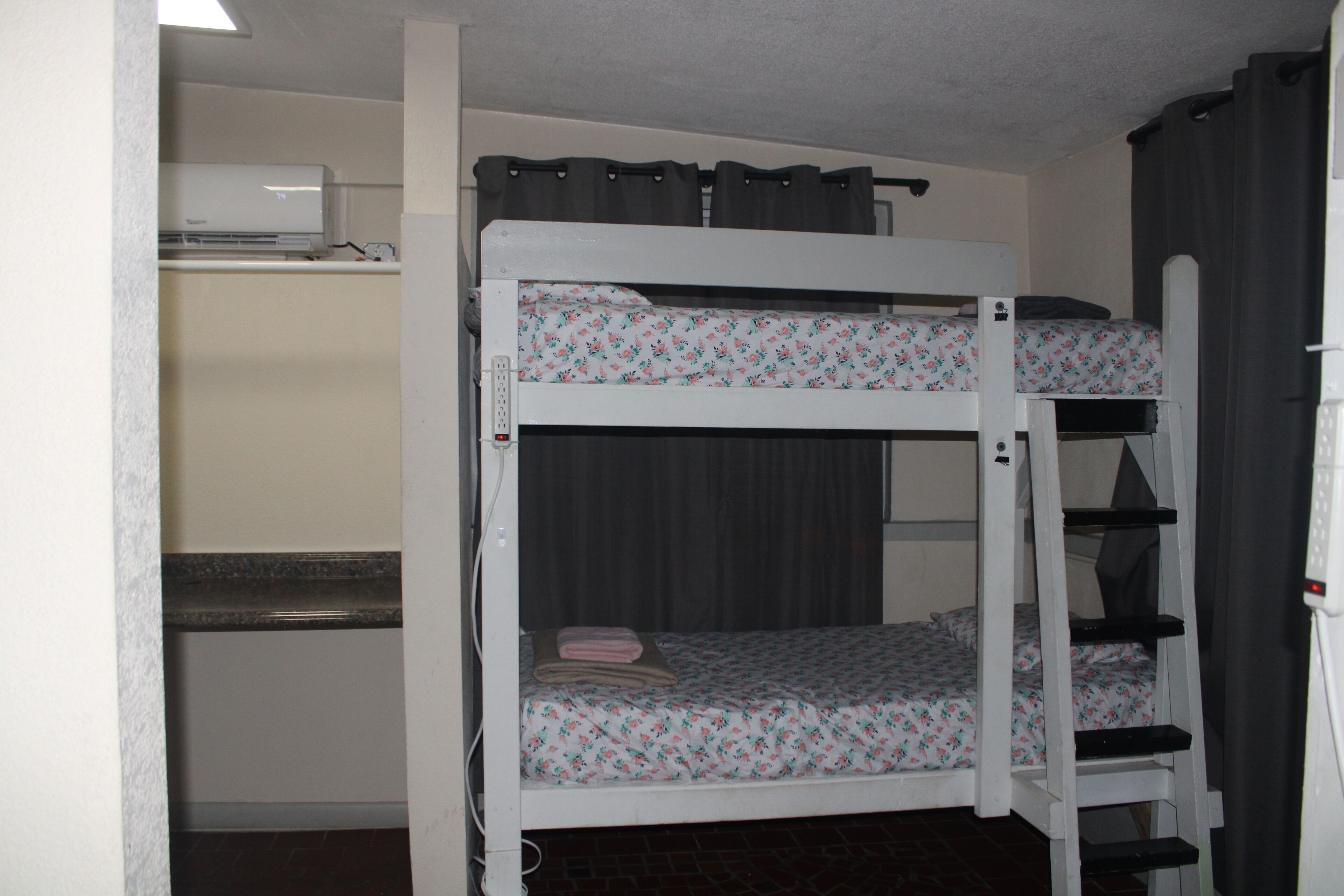 A bunk bed room with a desk and a heater.