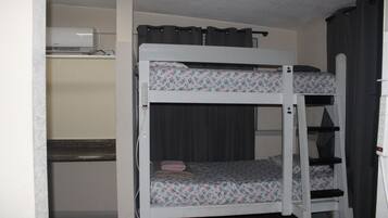 A bunk bed room with a desk and a heater.