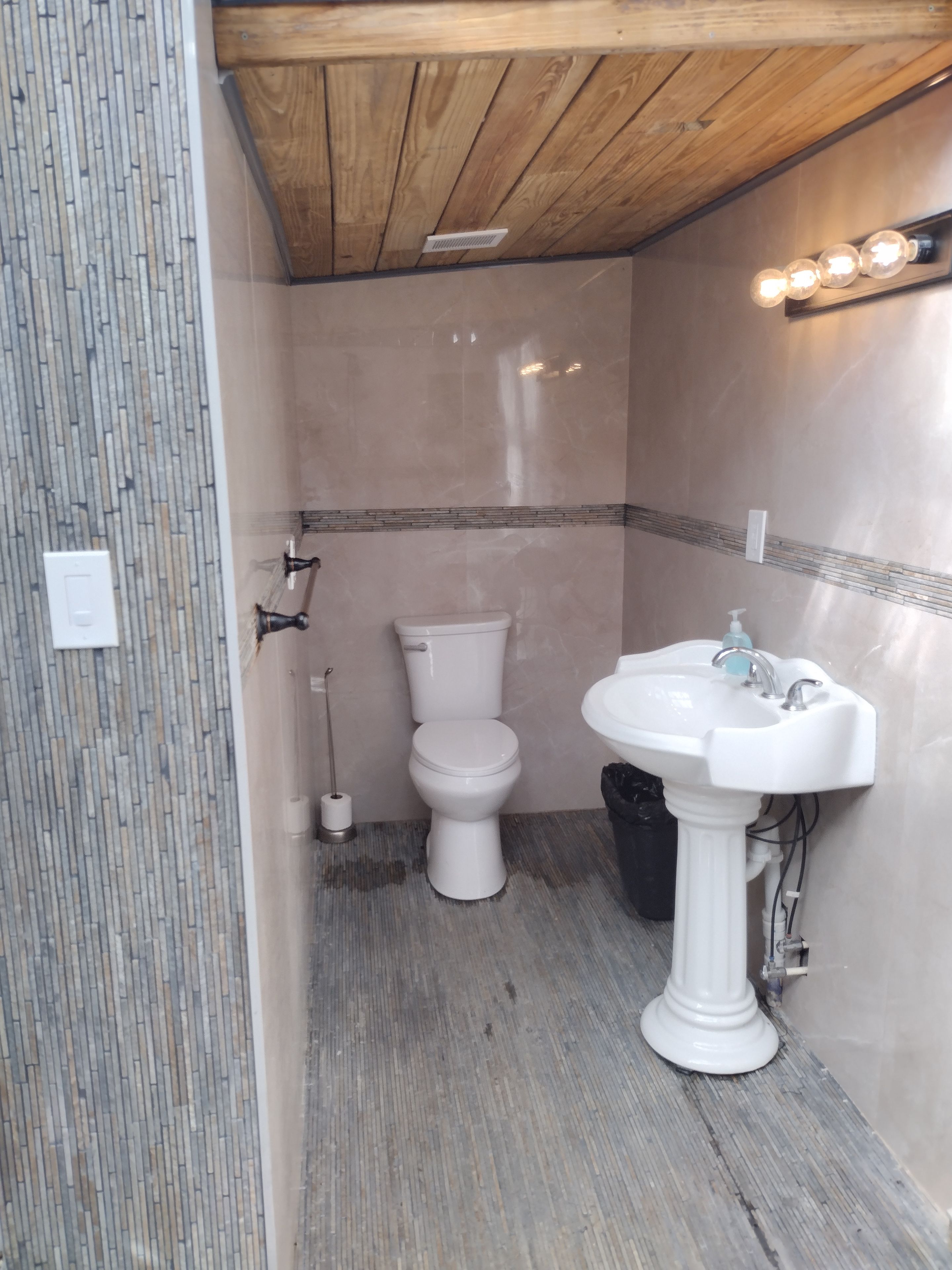 A bathroom with a toilet, sink, and shower.
