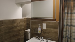 A bathroom with a sink, mirror, and toiletries dispenser. - Hoosville Hostel (Florida City)