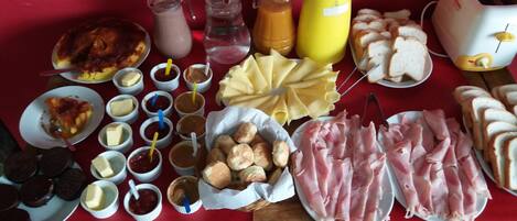 Una mesa con distintos alimentos, como pan, queso y embutidos.