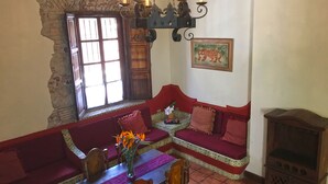 Ein gemütliches Wohnzimmer mit einem roten Sofa, einem Holztisch mit Blumenvase und einem Kamin.