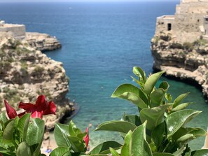 A coastal view with rocky cliffs and a clear blue sea.