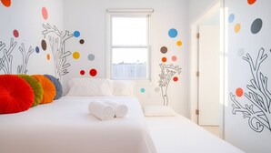Une chambre d’hôtel avec un lit, des oreillers, une fenêtre et des éléments de décoration murale.