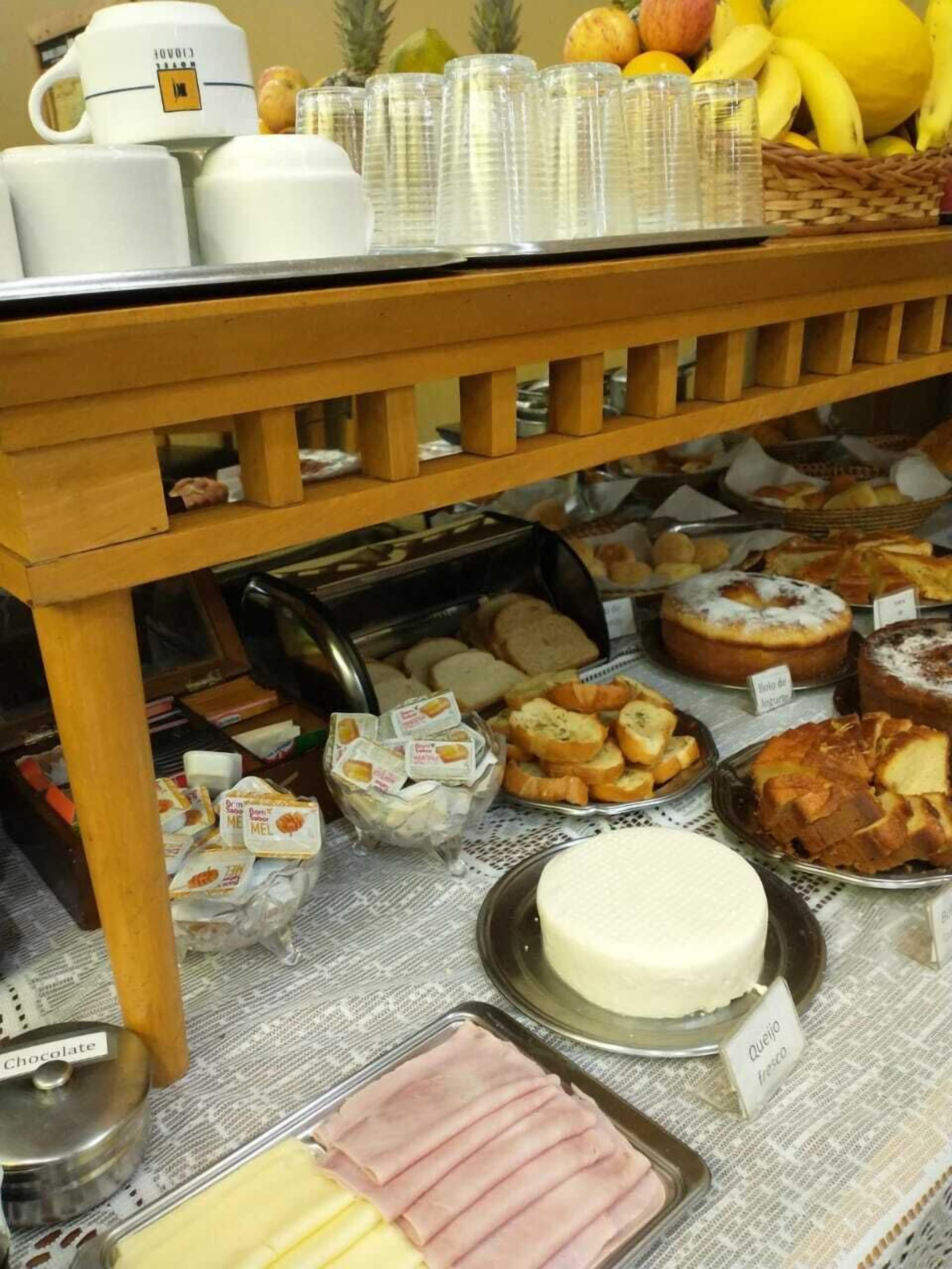 Una mesa de buffet con diversos alimentos, como pan, pasteles y queso.