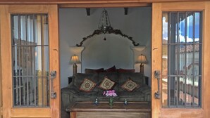 A cozy living room with a sofa, two lamps, and a decorative mirror. - Casa Hermano Pedro (Antigua Guatemala)