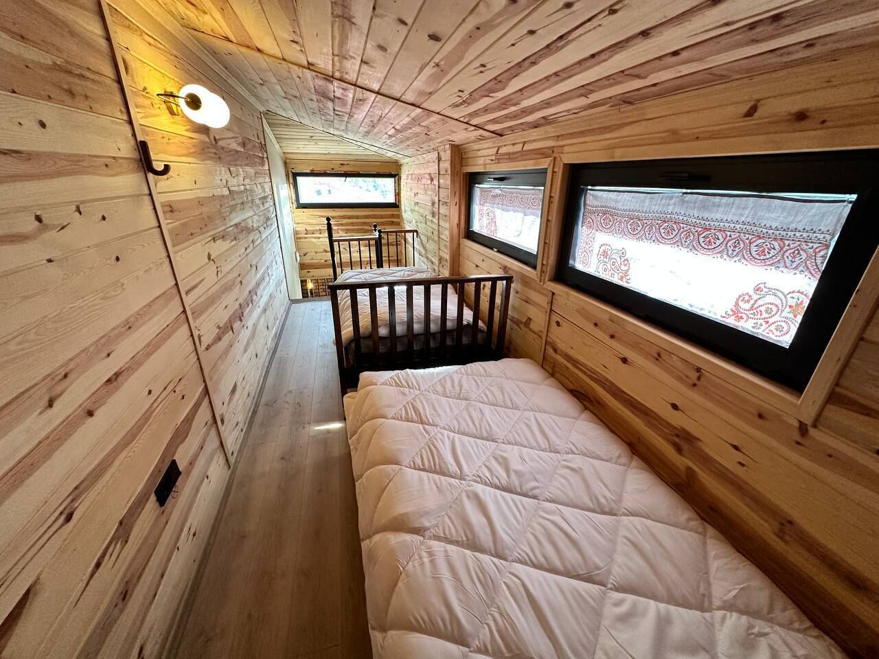 A cabin with a bed, a window with a view, and a small table.