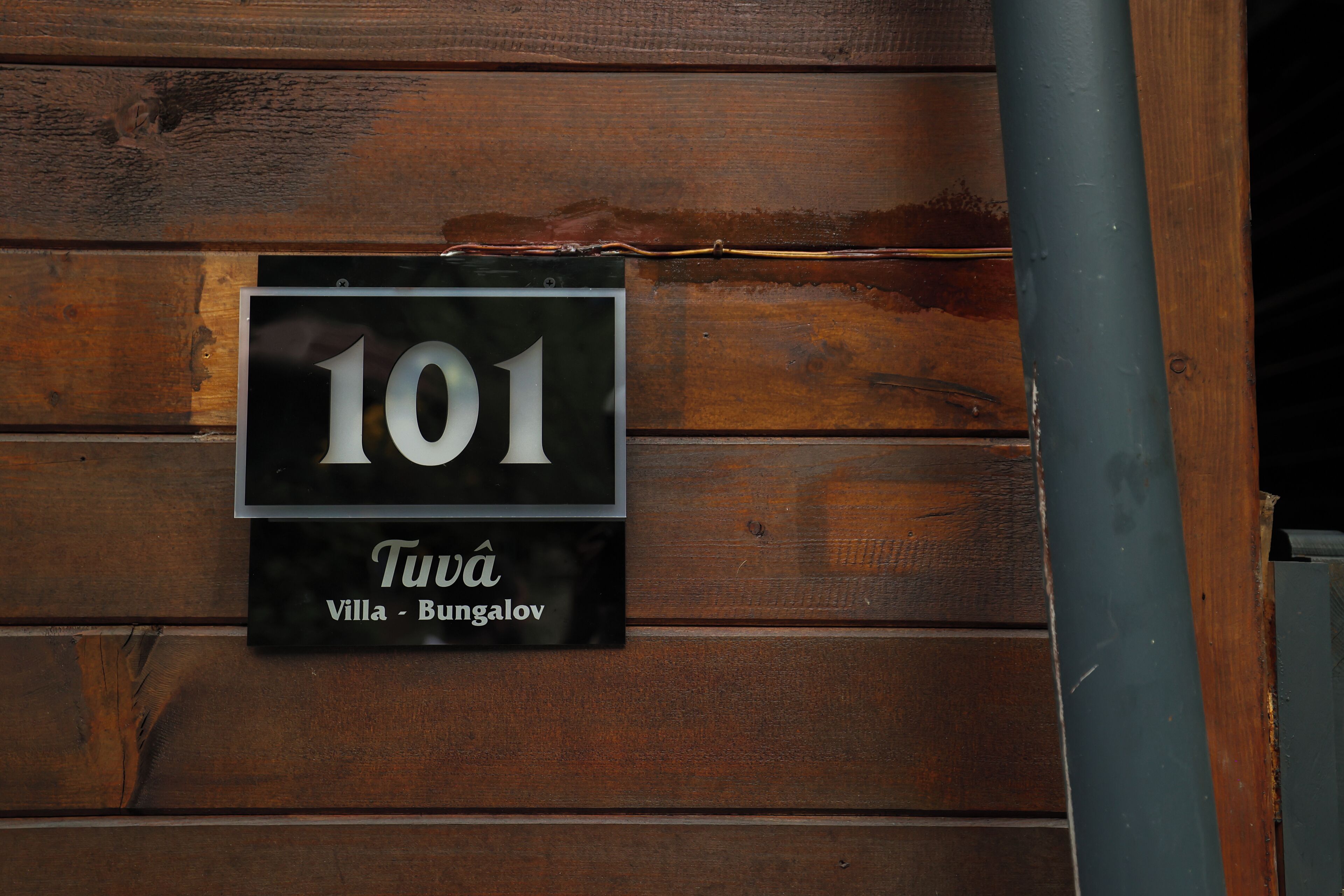A wooden wall with a sign indicating room number 101, named 'Villa - Bungalov'.