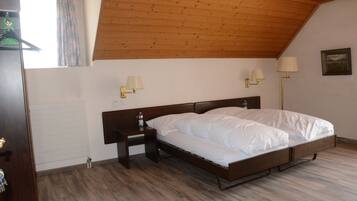 A bedroom with a wooden ceiling, a bed, bedside lamps, and a nightstand.