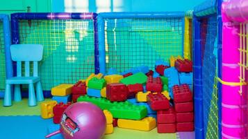 Ein Spielbereich mit bunten Bauklötzen und einem rosa Ball.