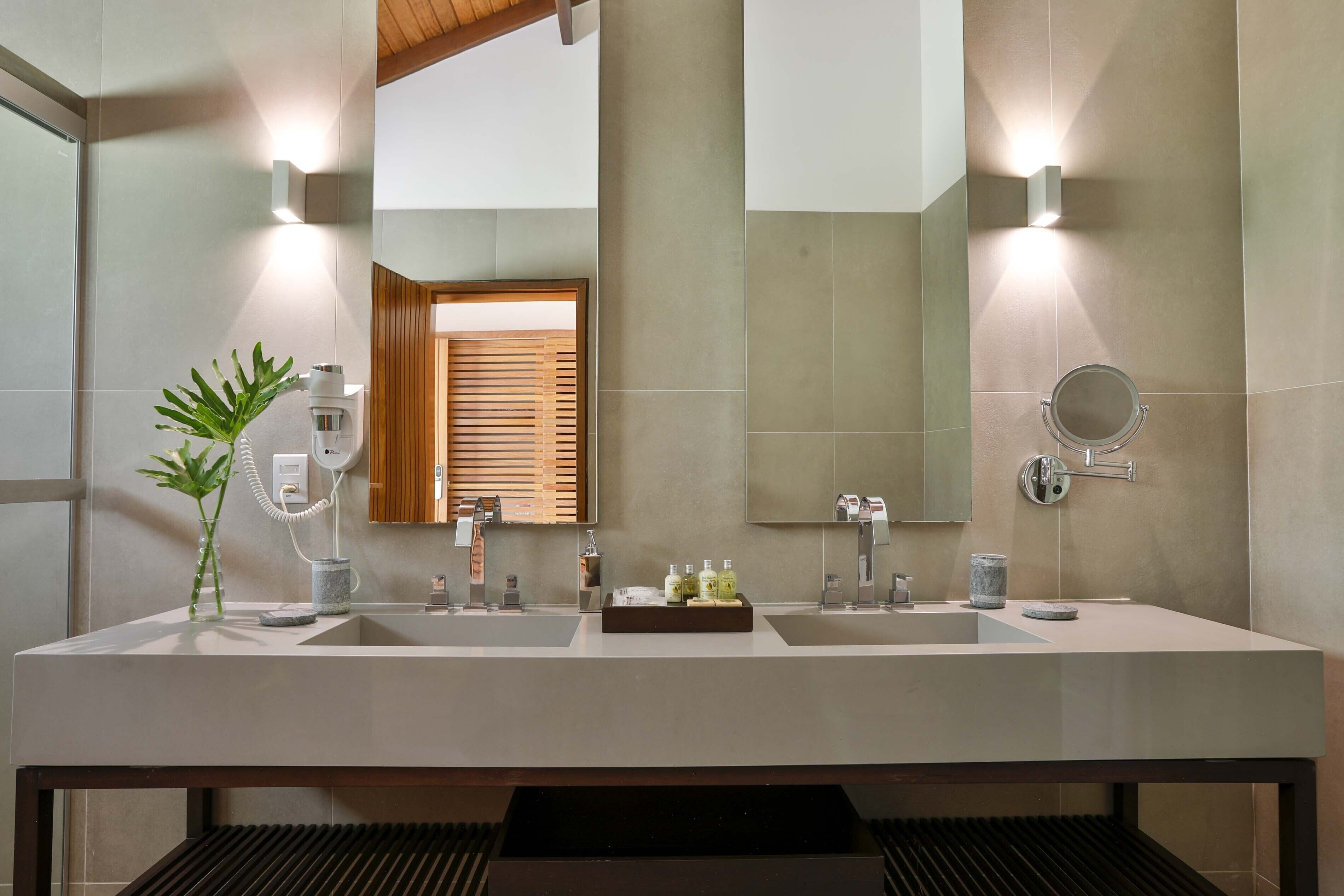 A modern bathroom with two sinks, a large mirror, and a wooden window.