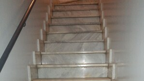 Una escalera con escalones de mármol y barandilla.