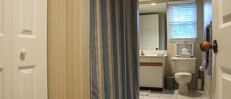 A bathroom with a toilet, sink, and shower curtain.