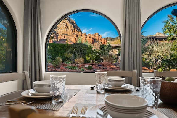 Enjoy meals in this dining area with a table set for a meal, offering a view of the surrounding landscape.