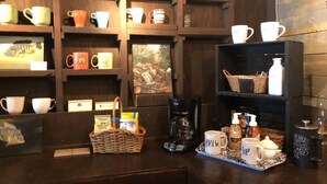 A coffee shop interior with shelves of mugs, a coffee machine, and a tray with coffee cups and a sign. - The Barn - Only 5 minutes to I65 (Montevallo)