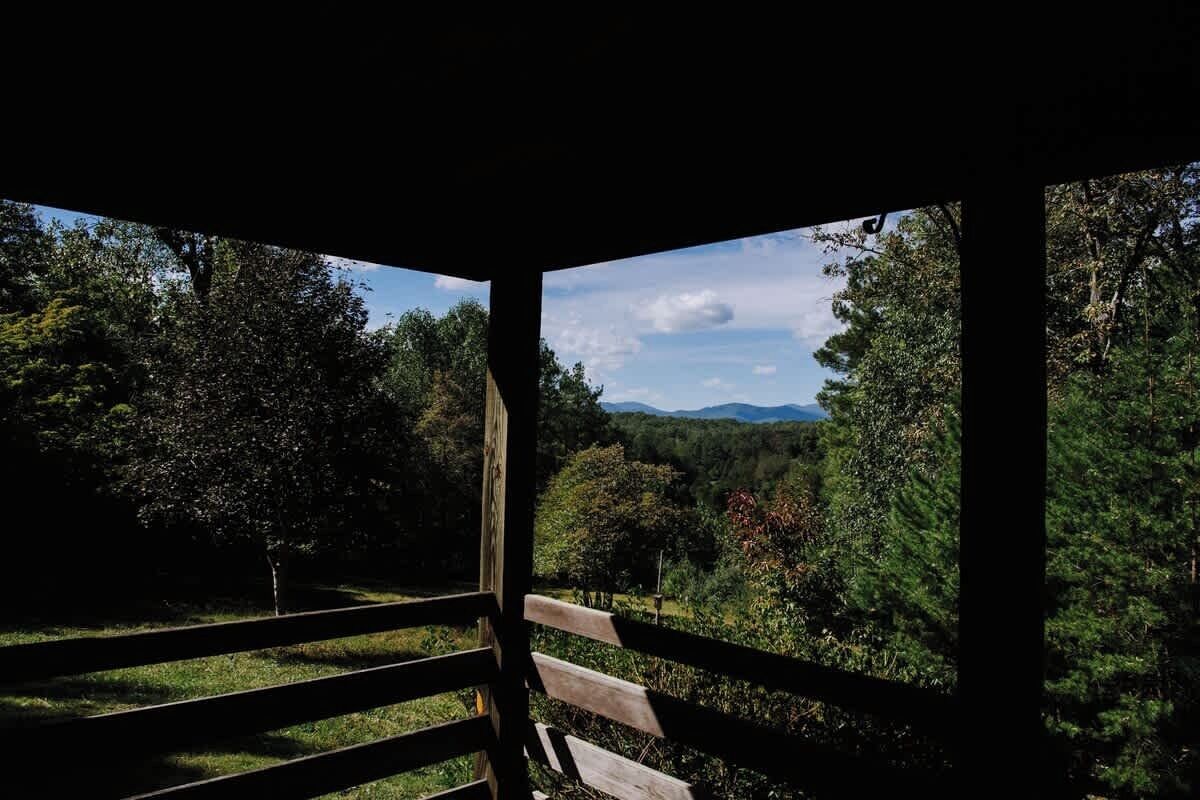 A wooden structure with a view of a forested landscape.