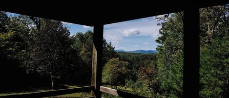 A wooden structure with a view of a forested landscape.