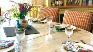 Ett matbord dukat med tallrikar, bestick och glas, med en vas med blommor och en bordsdekoration på bordet.