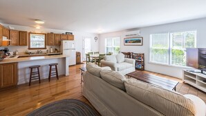 A spacious living area with a kitchen, a dining table, and a sofa. - Beautiful 3 bedroom  2 bath Home / Close to Town & Beach (Oak Bluffs)