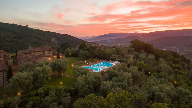 A pool surrounded by trees and buildings, with a sunset in the background. - Stunning private villa for 10 guests with private pool, WIFI, A/C, hot tub, TV and panoramic view (Monsummano Terme)