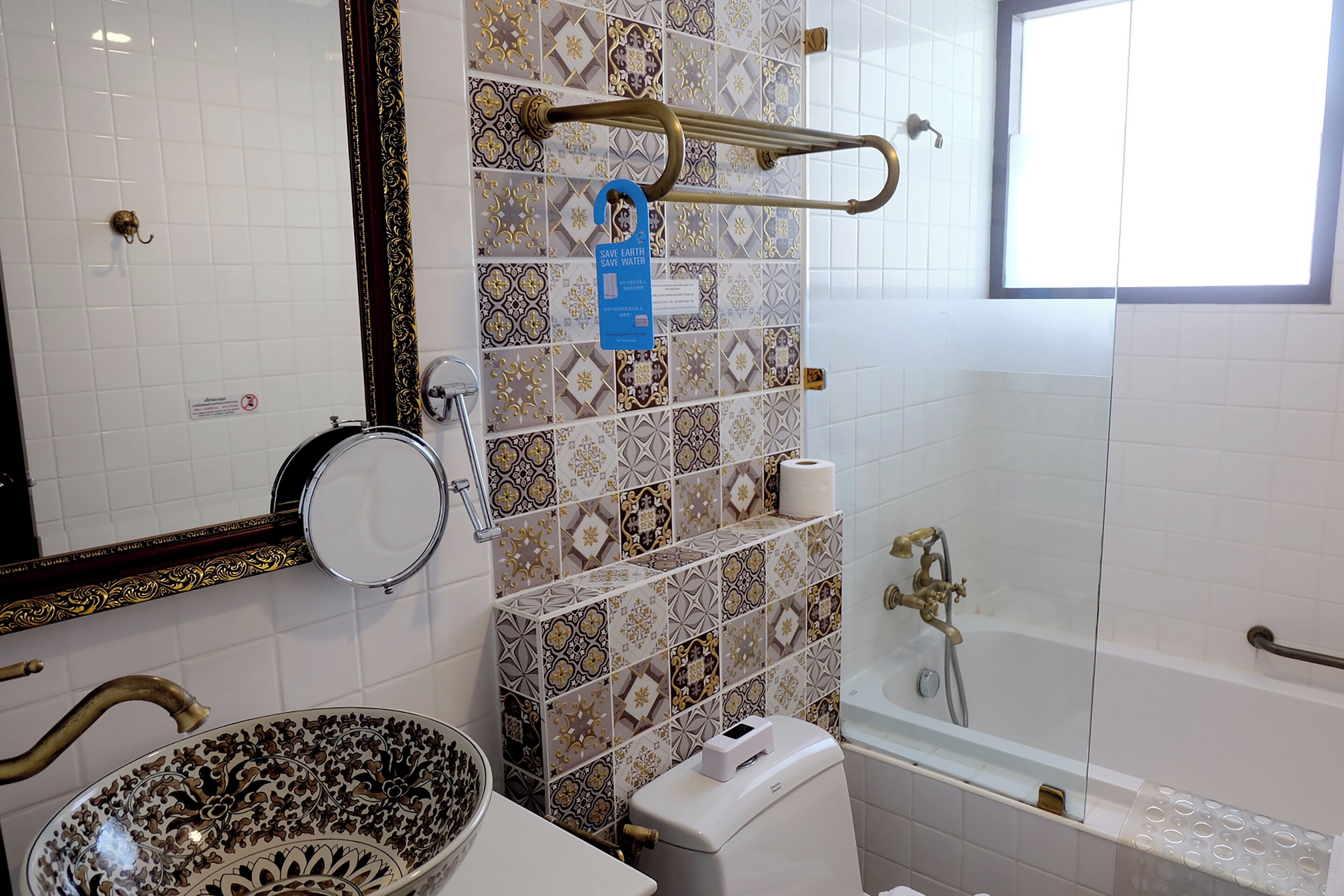 A bathroom with a large bowl sink, a toilet, a bathtub, and a shower.