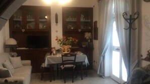 Ein gemütliches Wohnzimmer mit Essbereich, Holzschränken und einem Fernseher.